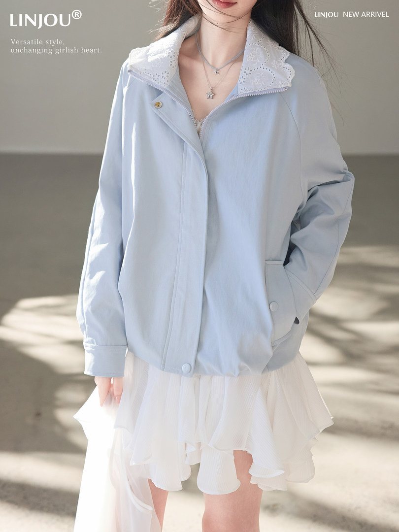 Model wearing a light blue jacket with a lace collar and a white skirt