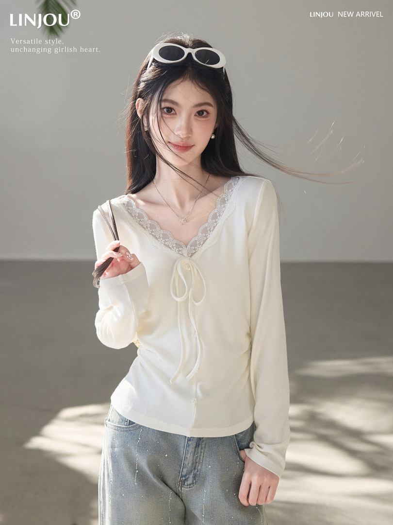Woman wearing a white lace-trim long-sleeve top with jeans