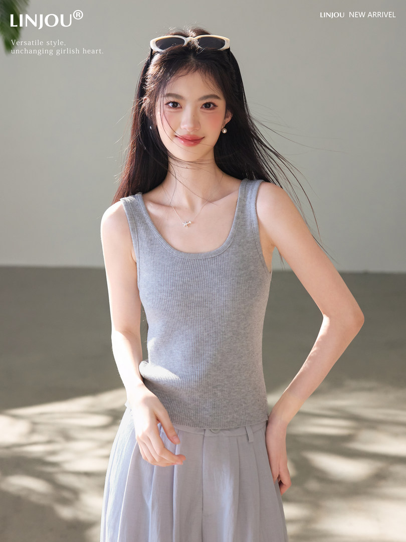 Model wearing a gray ribbed sleeveless tank top and matching light skirt