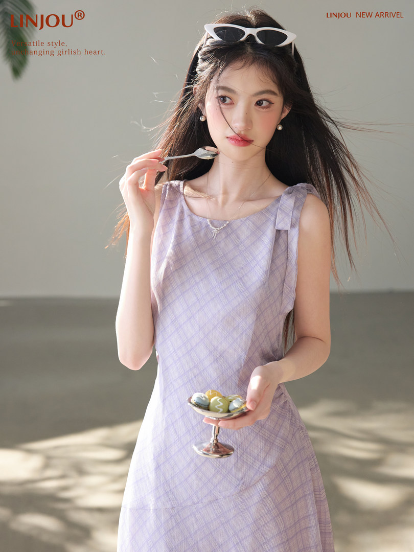 Model wearing a light purple sleeveless dress with sunglasses
