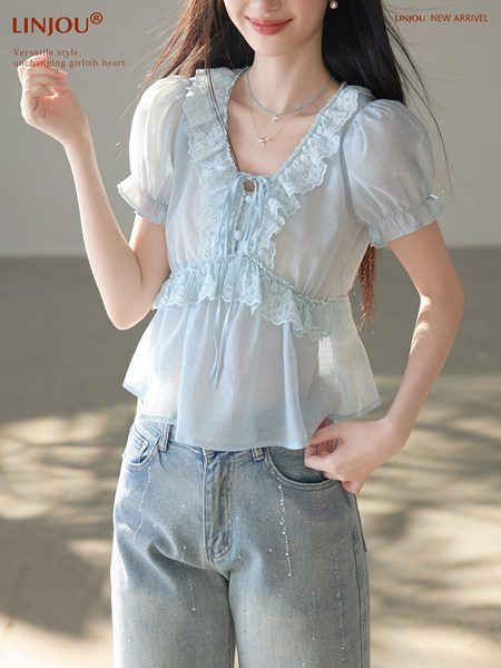 Model wearing a light blue lace-trim puff-sleeve blouse with jeans