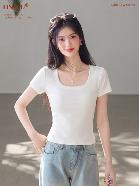 Woman wearing a white fitted short-sleeve scoop-neck T-shirt with light blue jeans