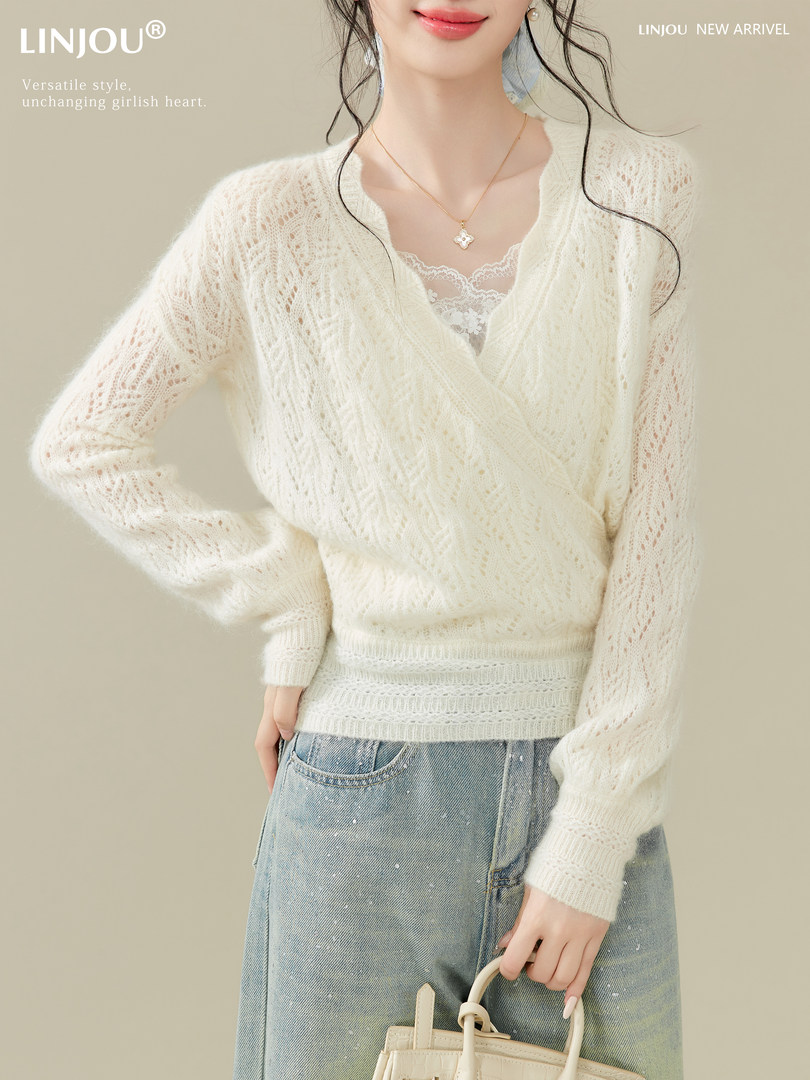 Woman modeling a cream knit sweater with light blue jeans