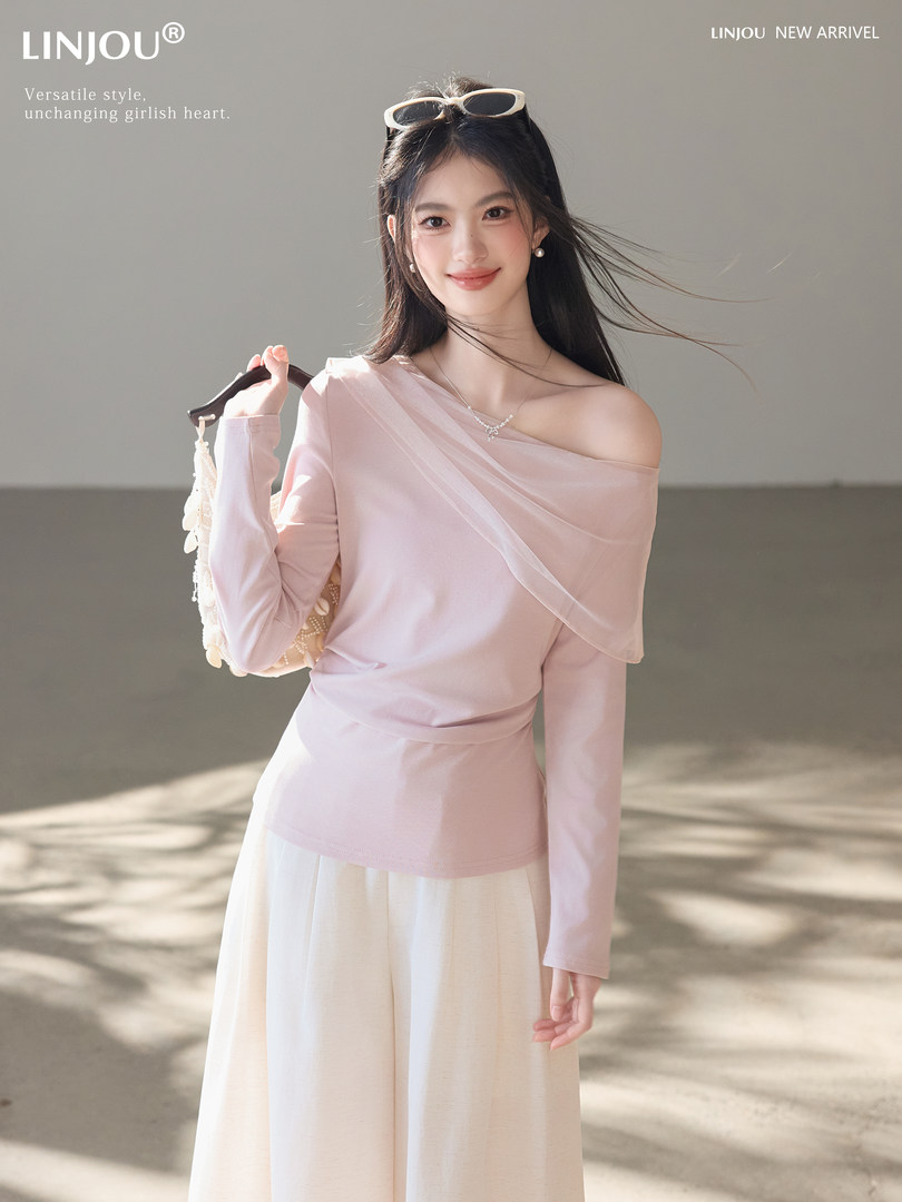 Woman wearing a light pink off-shoulder top with a cream skirt on a model