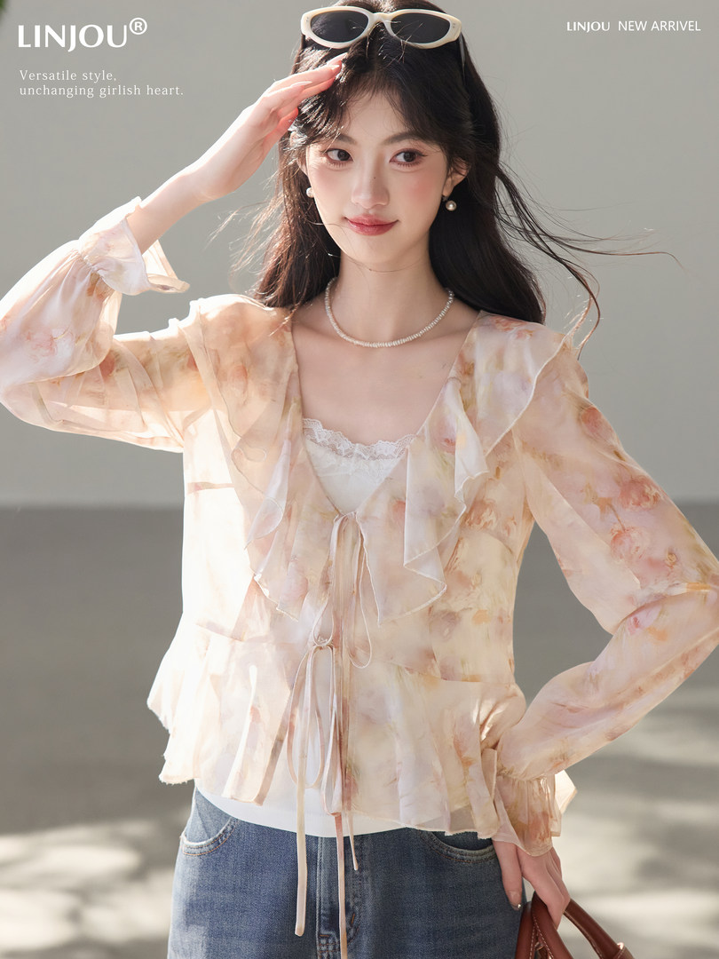 Model wearing a sheer floral ruffle blouse with jeans