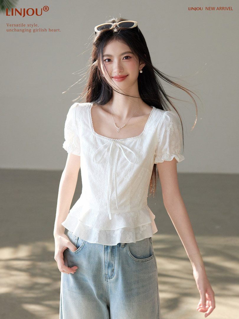 White short-sleeve peplum blouse worn with light denim bottoms