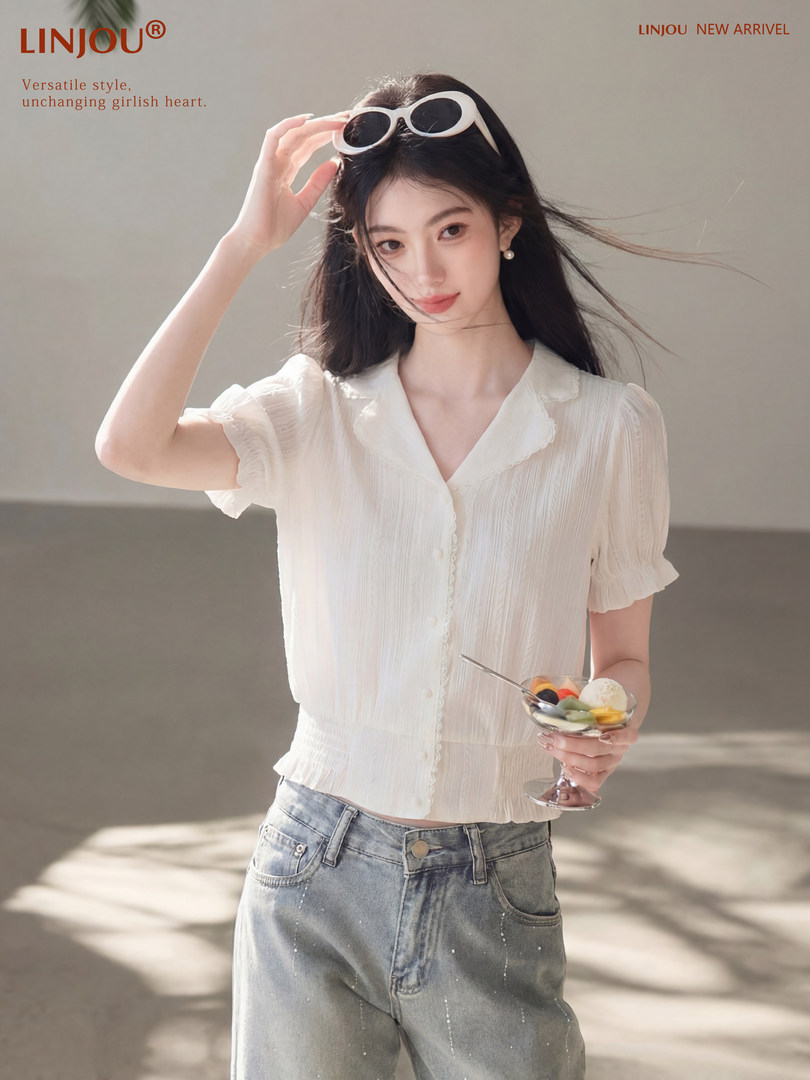 Model wearing a white short-sleeve blouse with light blue jeans