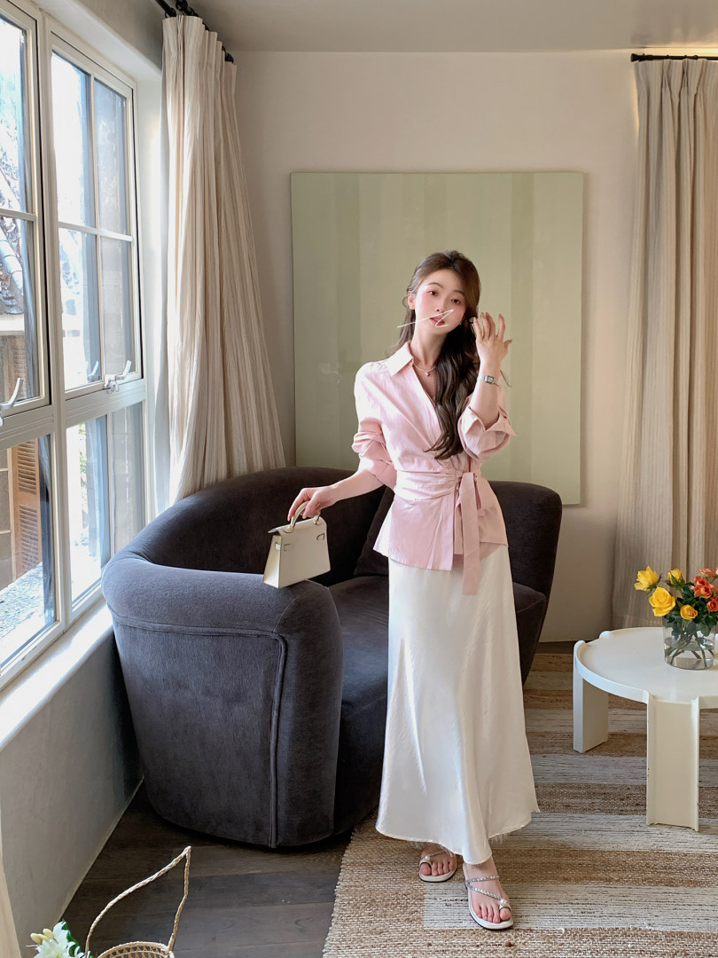 Woman wearing a pink wrap blouse with a white maxi skirt