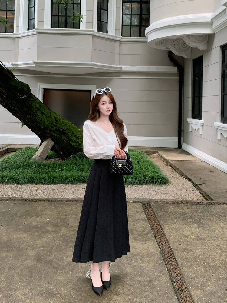 Woman wearing a white blouse with a black midi skirt and black heels