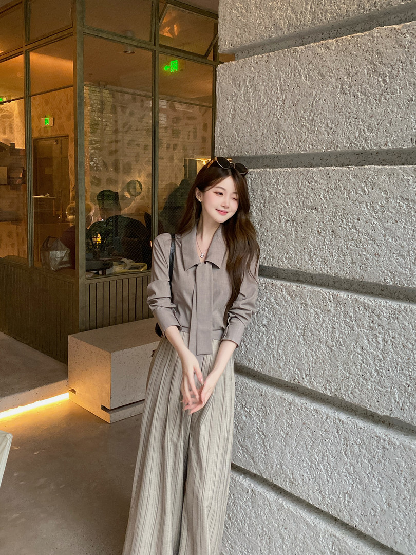 Woman wearing a neutral-toned blouse and wide-leg striped pants