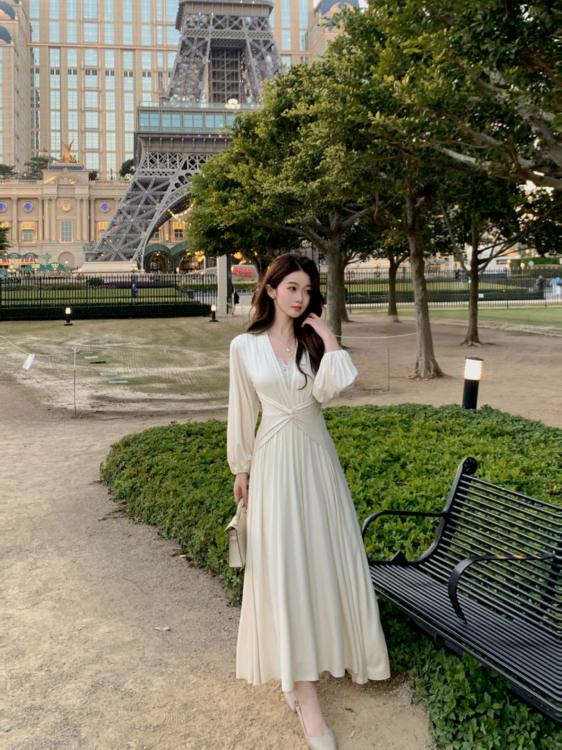 Woman wearing a cream long-sleeve midi dress outdoors