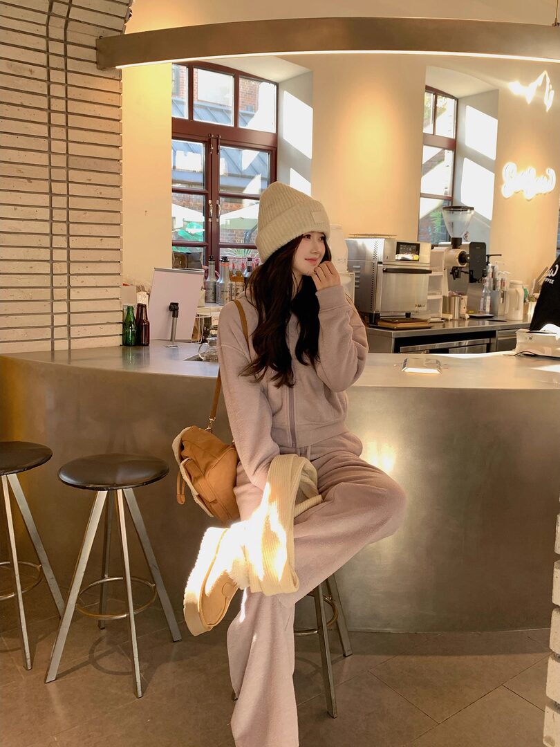 Woman wearing a cozy knit loungewear set and beanie in a cafe