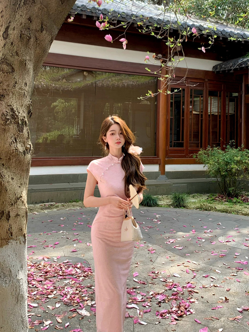 Woman wearing a pink fitted cheongsam-style dress outdoors