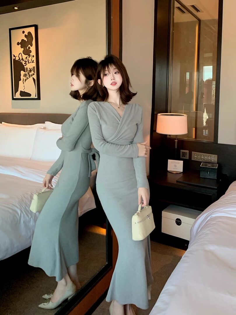 Light gray long-sleeve wrap midi dress worn by a woman indoors