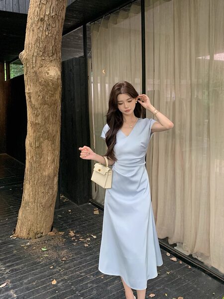 Light blue midi dress worn by a model with a small cream handbag