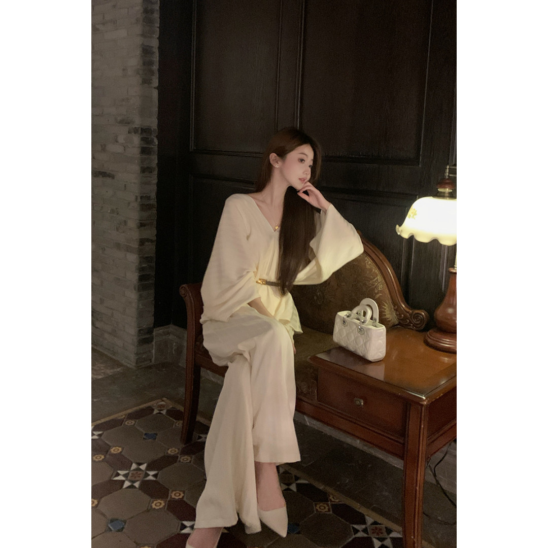 Cream elegant dress worn by a model with a small white handbag