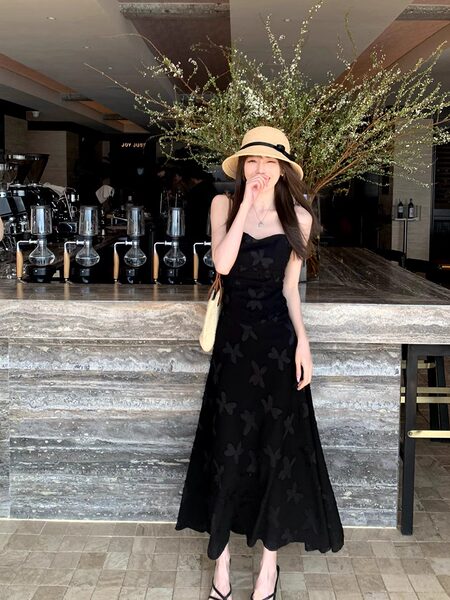 Black strappy midi dress with subtle floral pattern worn by a model