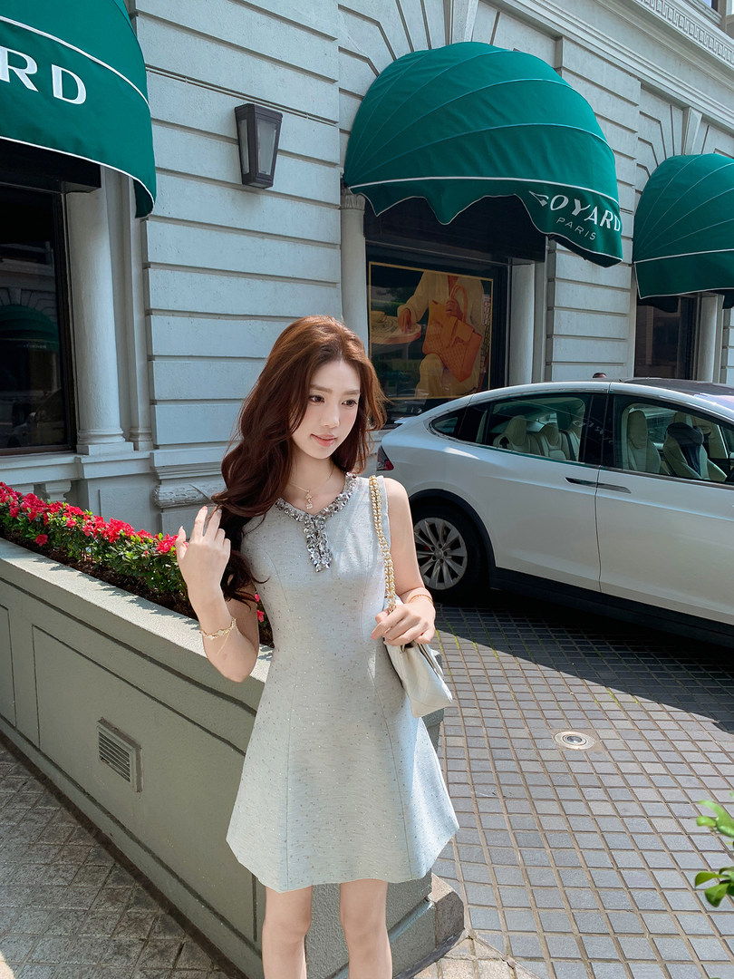 Woman wearing a light blue sleeveless dress outdoors