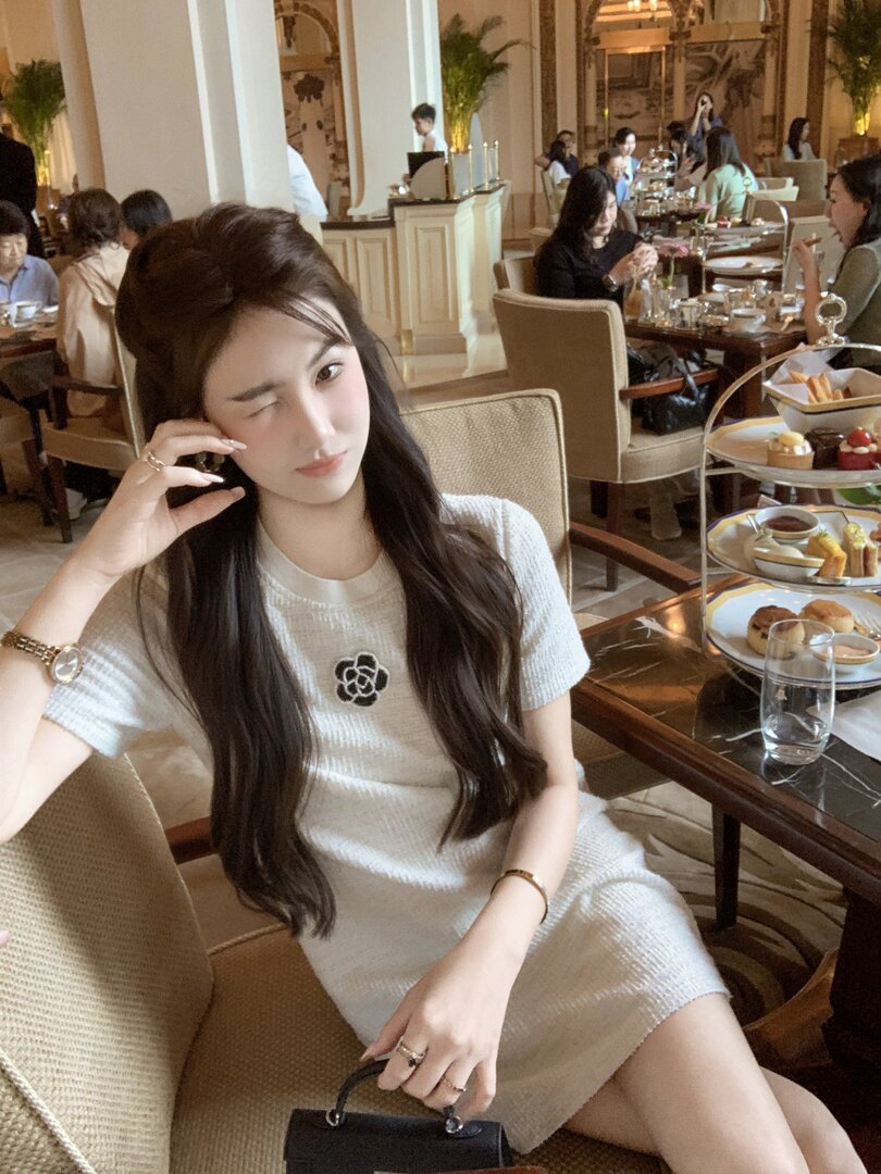 Woman wearing a white knit dress in a restaurant setting