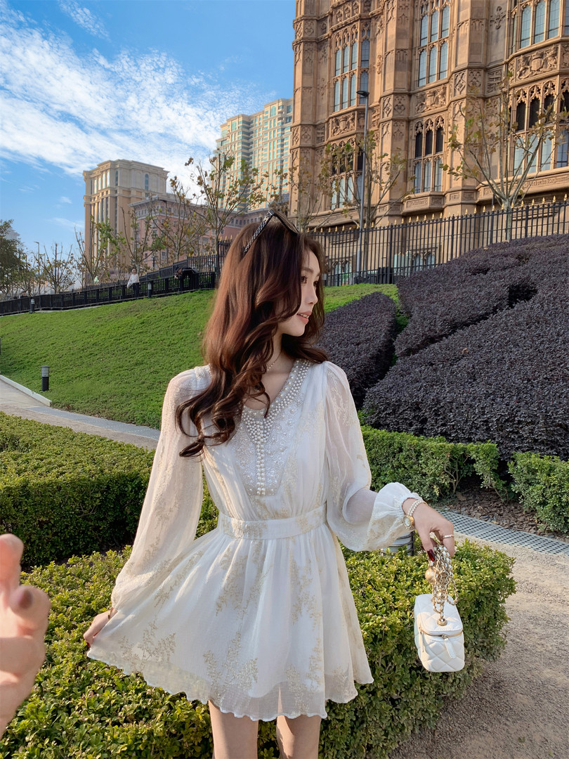 White sheer long-sleeve dress worn by a woman outdoors