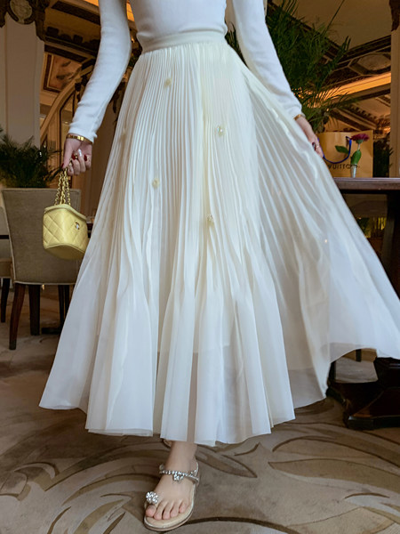 White pleated midi skirt worn with a fitted top and heels