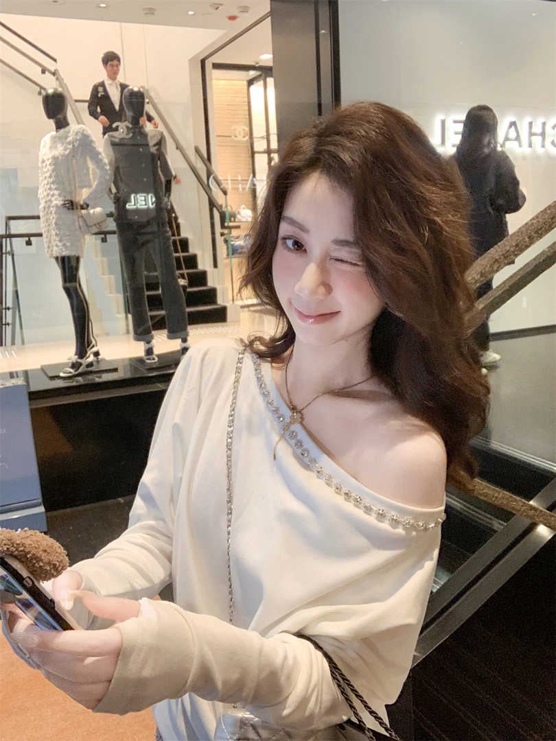 Woman wearing a white off-shoulder long-sleeve top in a boutique