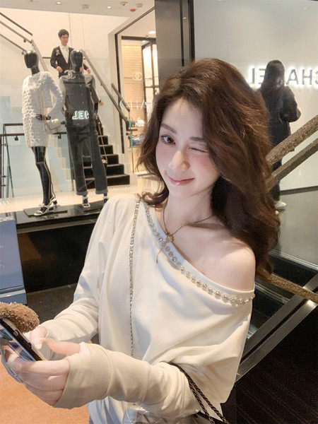 Woman wearing a white off-shoulder long-sleeve top in a boutique