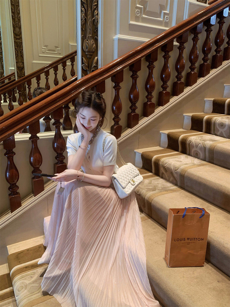 White quilted chain handbag worn on a model sitting on stairs