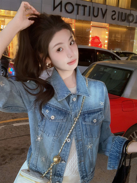 Woman wearing a light blue embellished denim jacket in a street setting