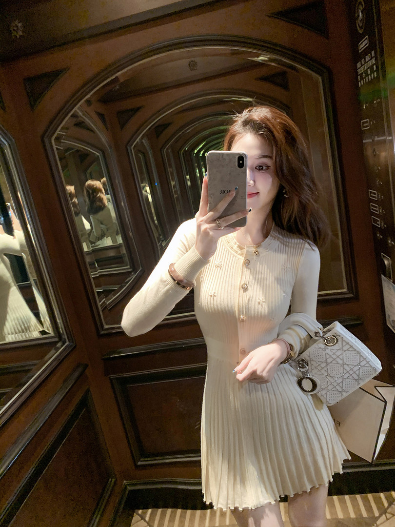 Cream ribbed long-sleeve pleated dress worn by a woman in a mirror selfie