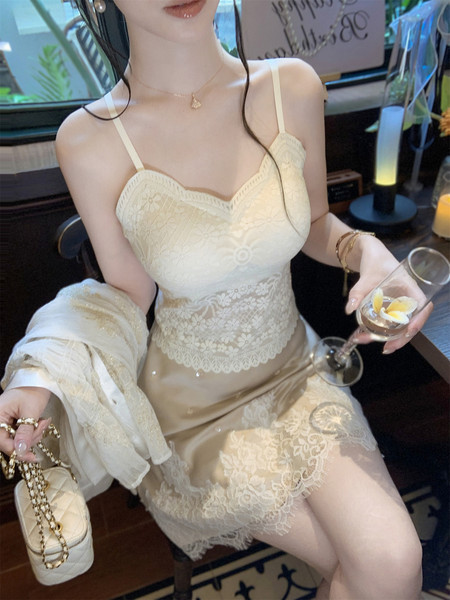 Woman wearing a cream lace slip dress with thin straps and matching shawl
