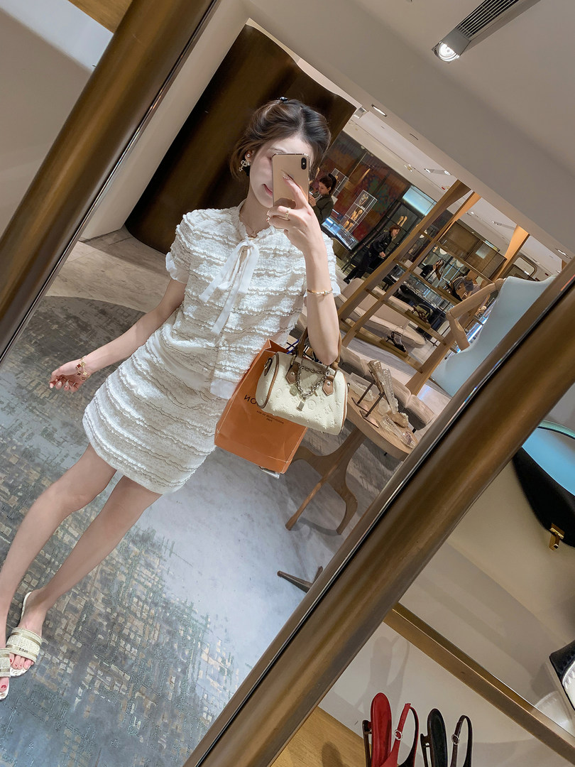 Woman wearing a white textured short dress in a mirror selfie