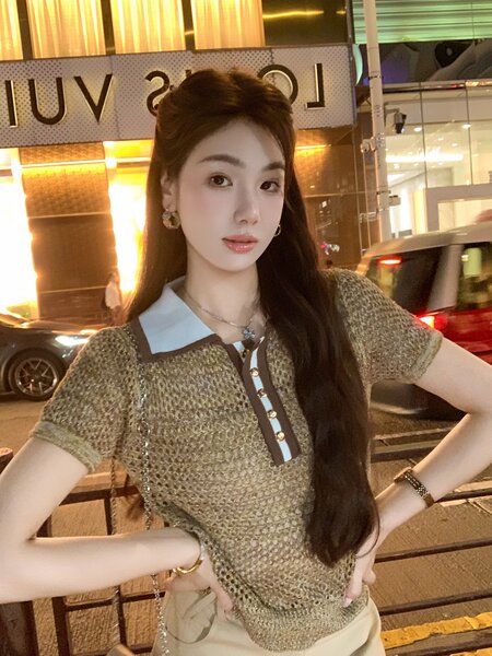 Woman wearing a short-sleeve knit polo-style top with contrast collar and button detail