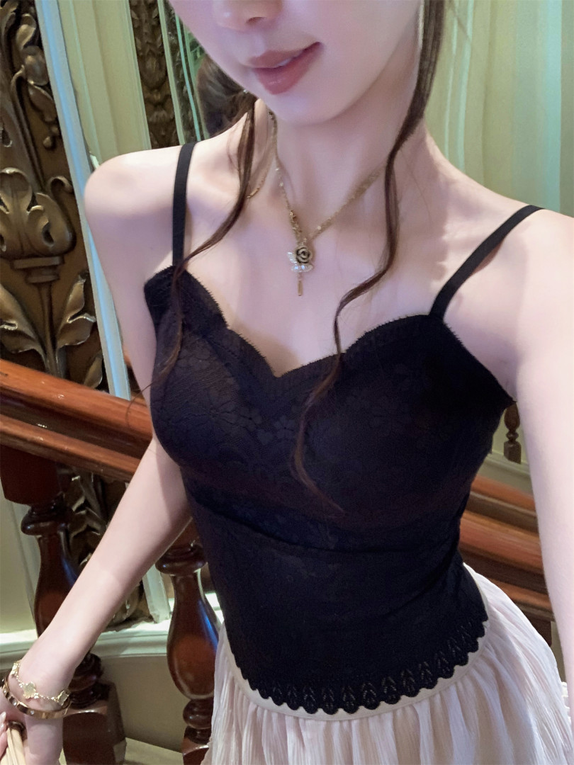 Black lace camisole top worn by a model with a pleated skirt