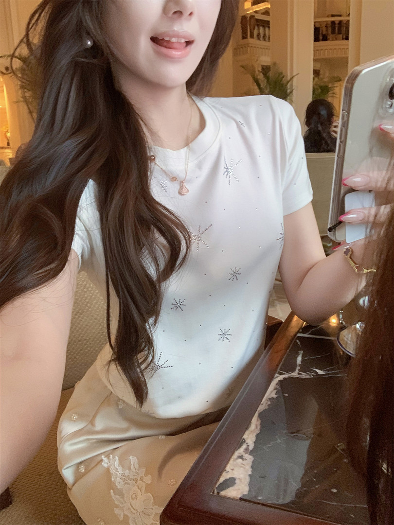 Woman wearing a white embellished short-sleeve top and satin skirt