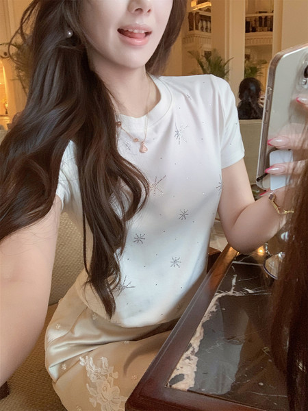 Woman wearing a white embellished short-sleeve top and satin skirt