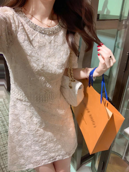Woman wearing a white lace short dress with beaded neckline