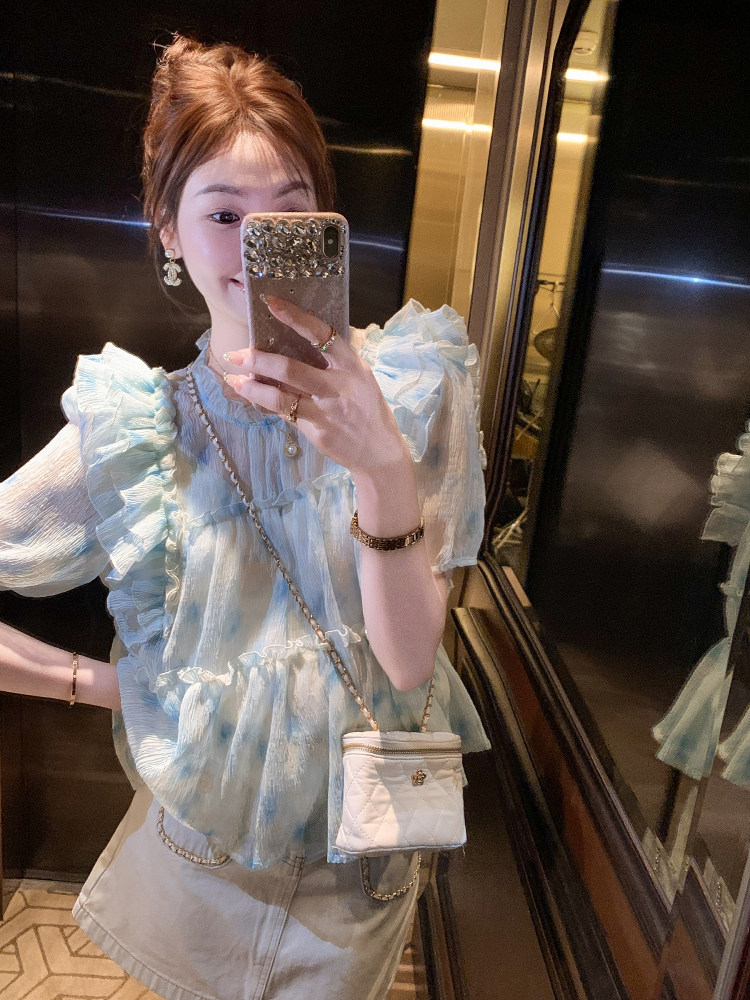 Light blue ruffled blouse worn with a white skirt