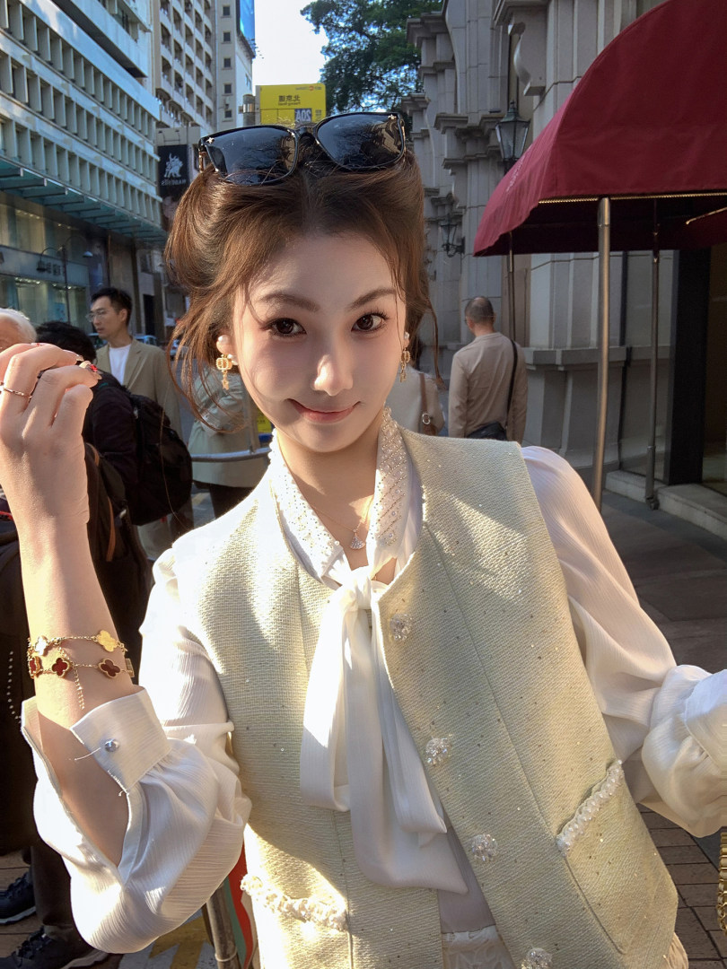Woman wearing a cream textured vest over a white blouse outdoors
