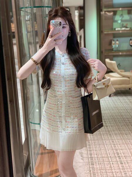 Woman wearing a light textured short-sleeve mini dress with a pleated hem