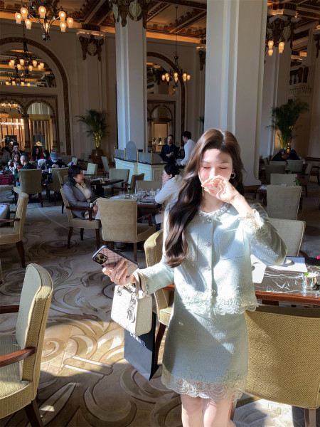 Woman wearing a light mint lace dress in a luxury restaurant