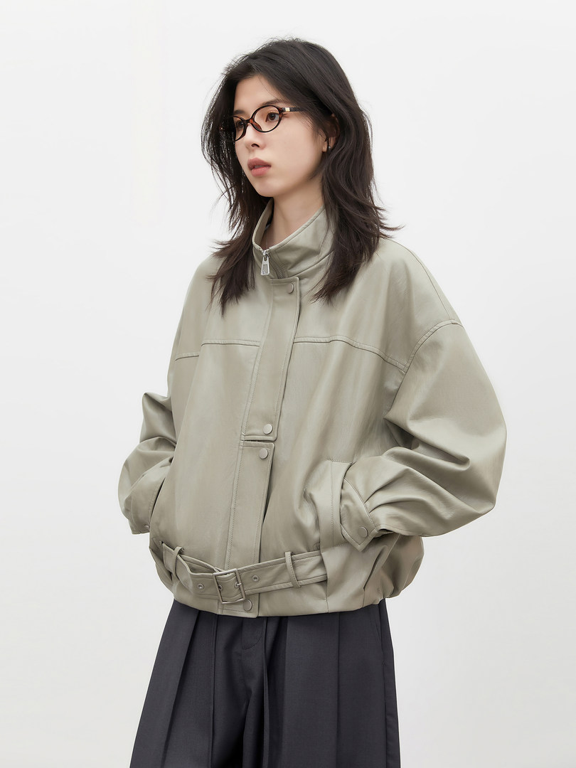 Model wearing a light gray belted jacket with a high collar and wide sleeves