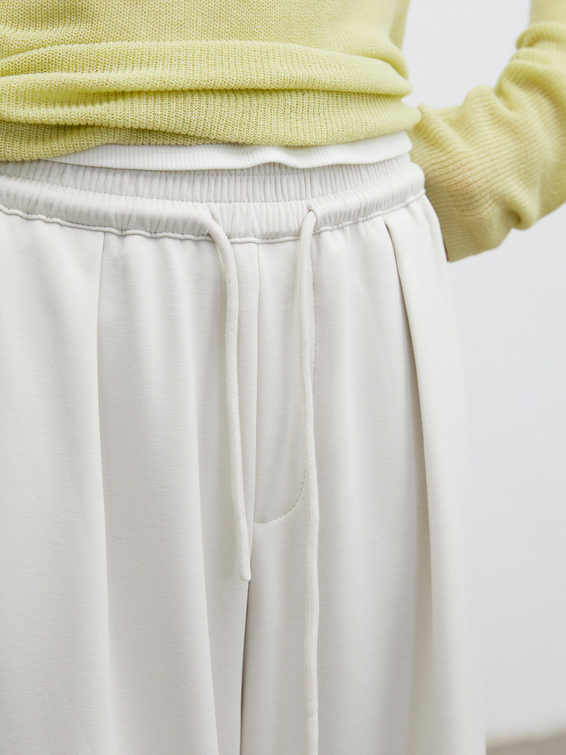Light-colored drawstring lounge pants worn with a pale yellow knit sweater