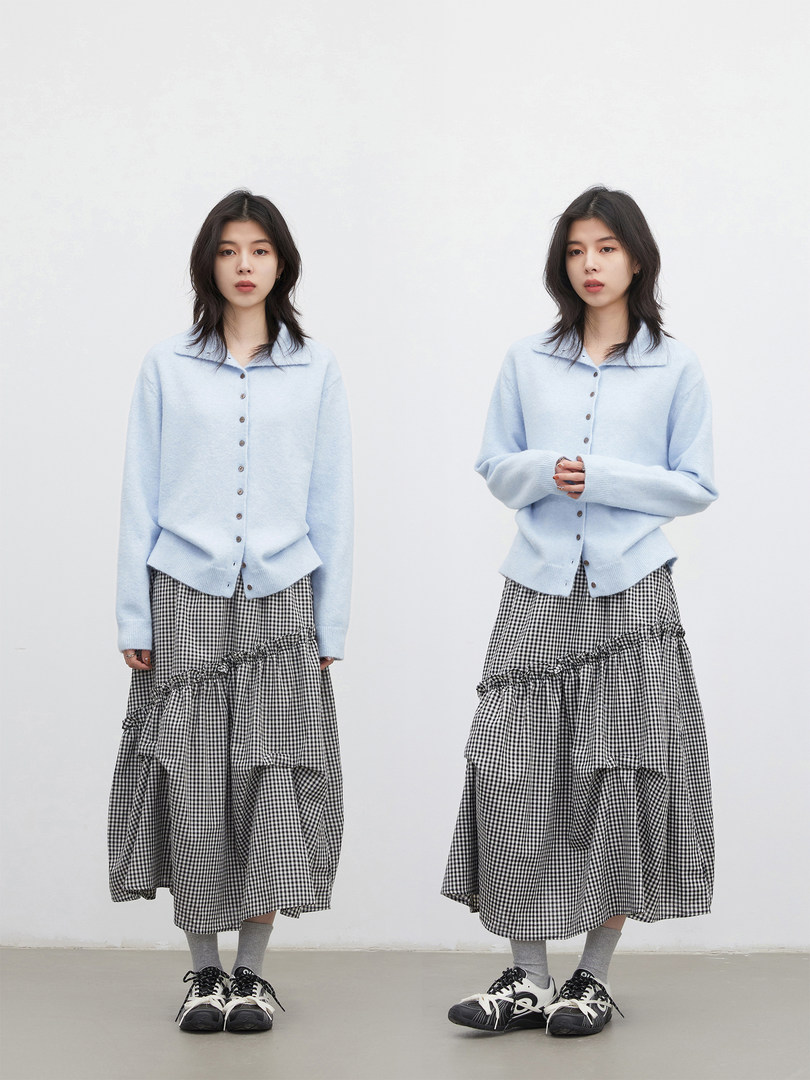 Model wearing a light blue cardigan with a black-and-white gingham skirt