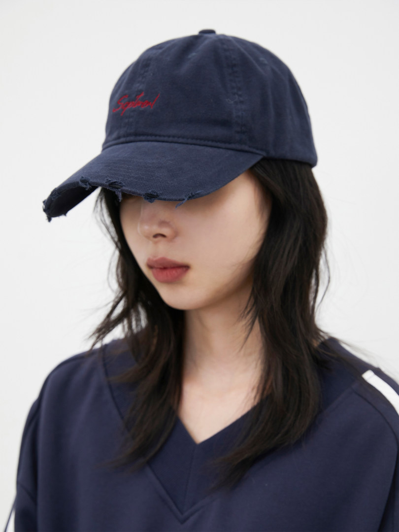 Navy distressed baseball cap worn by a model