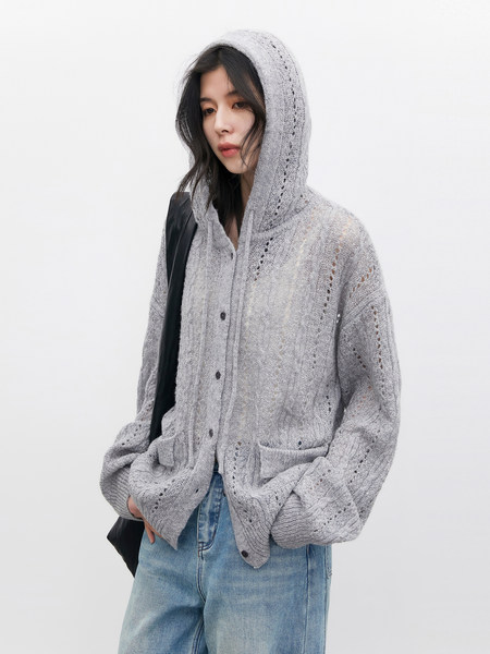 Model wearing a light gray knit hooded cardigan with pockets and jeans