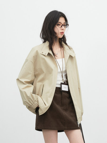 Model wearing a beige zip-front jacket with a brown skirt on a white background