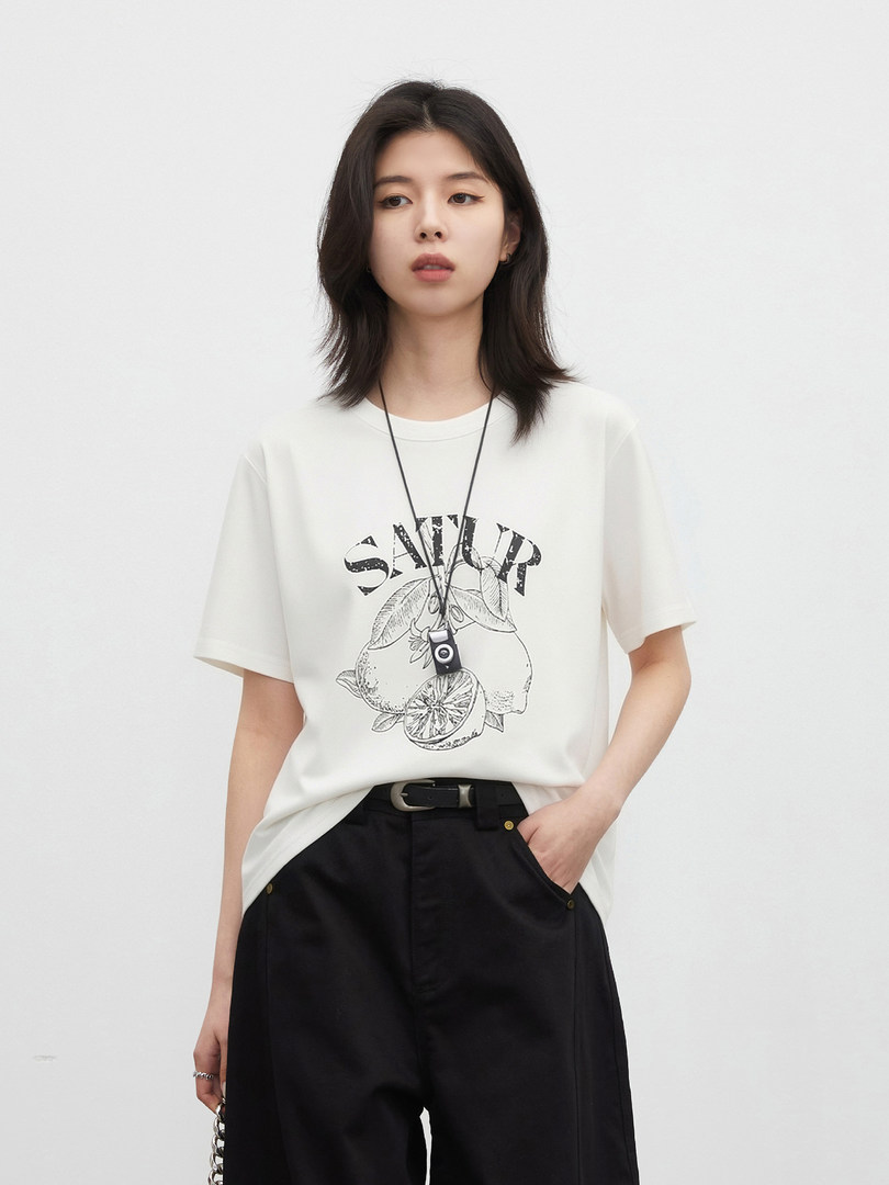Model wearing a white graphic T-shirt with black pants