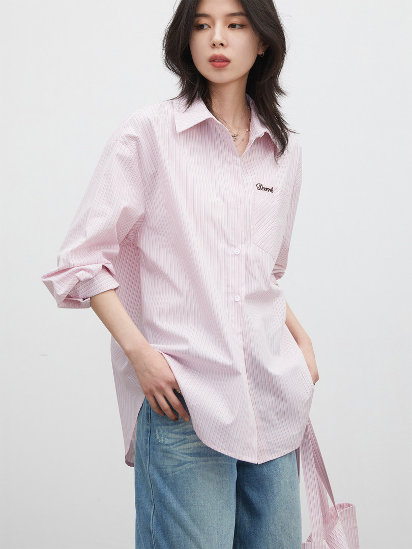 Model wearing a pink striped button-up shirt with long sleeves