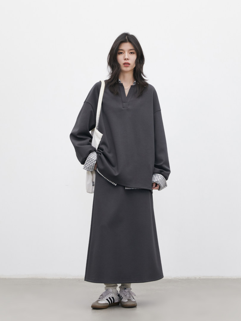Model wearing a dark gray oversized long-sleeve top with a matching long skirt